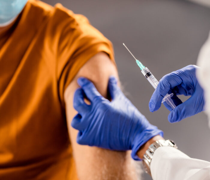 closeup healthcare worker giving vaccine senior patient
