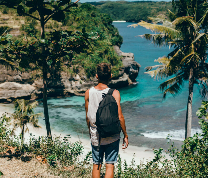 young guy with beard backpack posing jungle cap