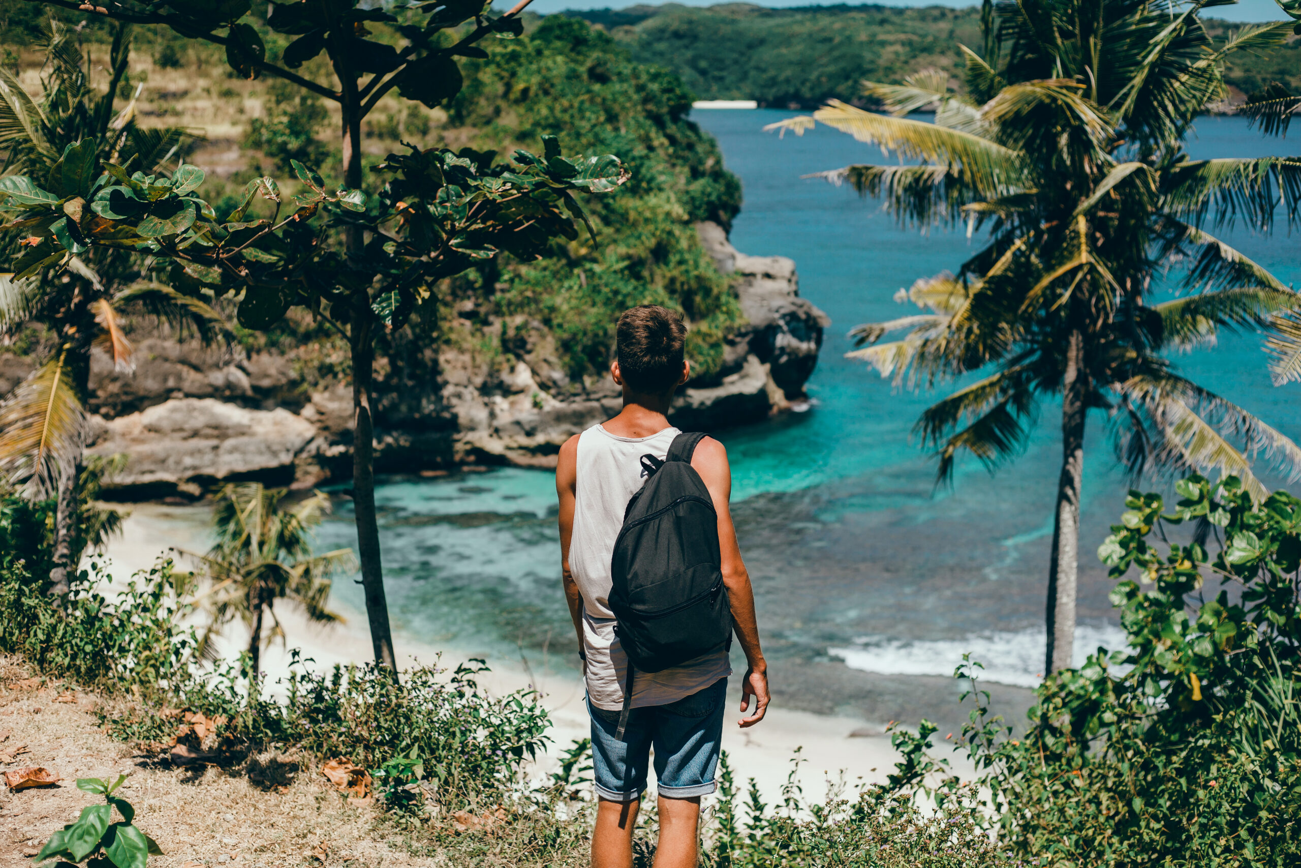 young guy with beard backpack posing jungle cap scaled